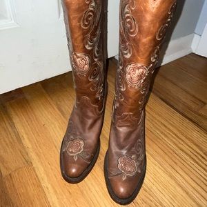 Tall women’s round toe cowgirl boots with floral detailing and smooth bottom.